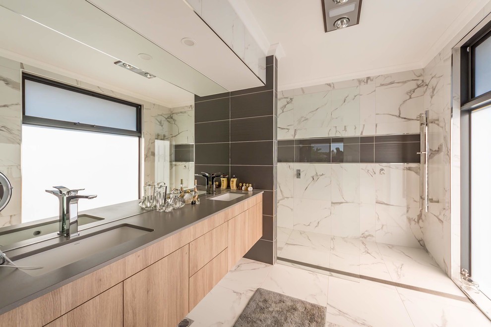 Foto di una stanza da bagno padronale contemporanea con ante lisce, ante in legno chiaro, doccia a filo pavimento, lavabo sottopiano, pavimento bianco, doccia aperta e top grigio