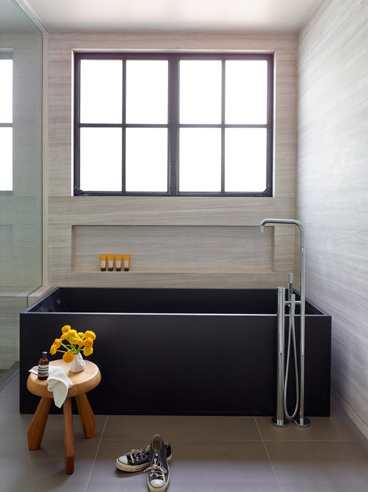 Medium sized contemporary ensuite wet room bathroom in Los Angeles with a corner bath, multi-coloured walls, ceramic flooring, grey floors, a hinged door and limestone tiles.