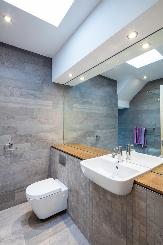 This is an example of a midcentury bathroom in Other with a wall mounted toilet and a built-in sink.