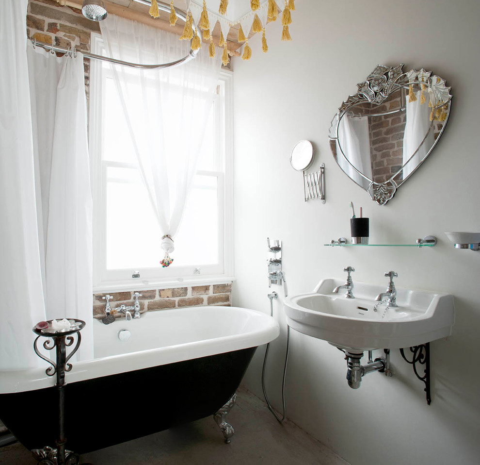 На фото: ванная комната в стиле лофт с подвесной раковиной, ванной на ножках, душем над ванной и белыми стенами с