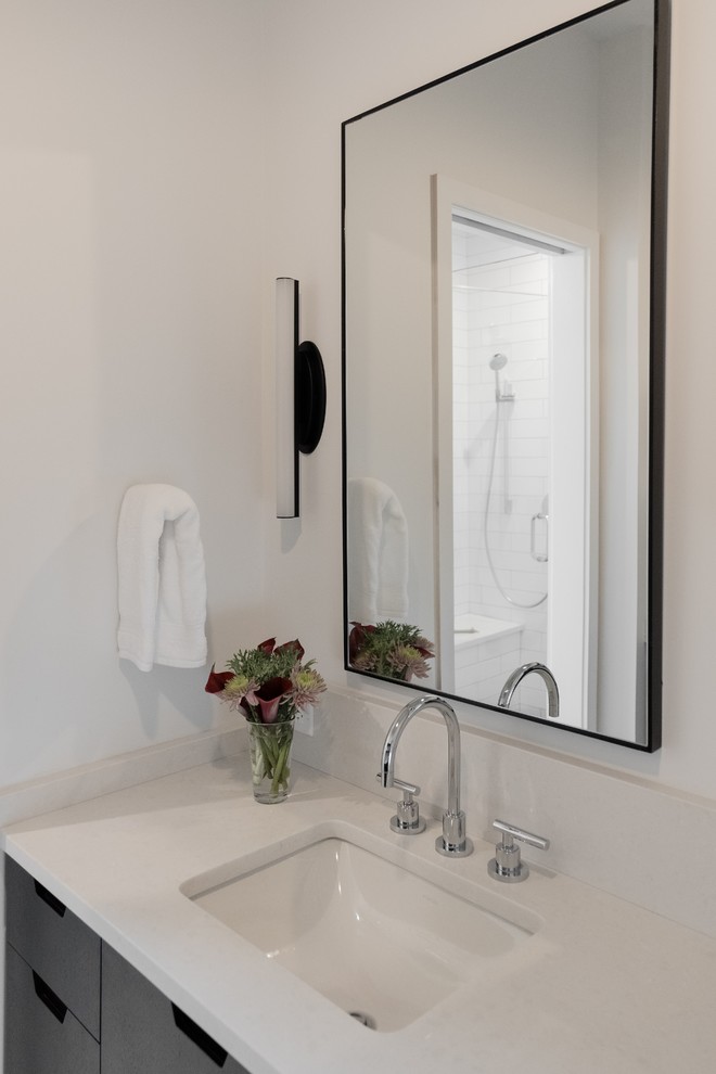 Idee per una stanza da bagno padronale minimalista di medie dimensioni con ante lisce, ante nere, WC a due pezzi, pareti bianche, pavimento con piastrelle in ceramica, lavabo sottopiano, top in quarzo composito, pavimento multicolore e top bianco