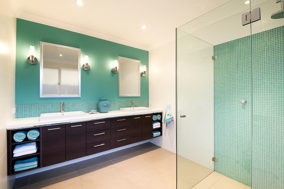 Bild på ett funkis en-suite badrum, med ett nedsänkt handfat, släta luckor, skåp i mörkt trä, vita väggar, bänkskiva i kvarts, en kantlös dusch, grön kakel, mosaik, klinkergolv i porslin och beiget golv