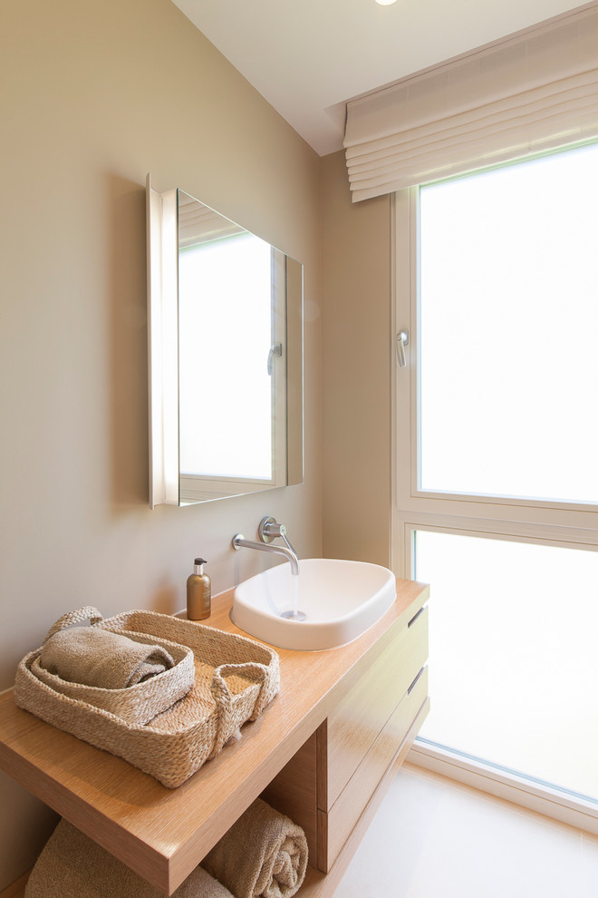 Idéer för att renovera ett litet funkis en-suite badrum, med ett undermonterad handfat, släta luckor, skåp i mellenmörkt trä, träbänkskiva och klinkergolv i keramik
