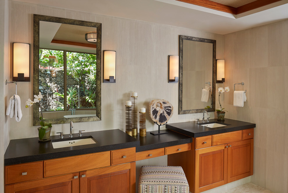 Imagen de cuarto de baño exótico con lavabo bajoencimera, armarios con paneles con relieve y puertas de armario de madera oscura