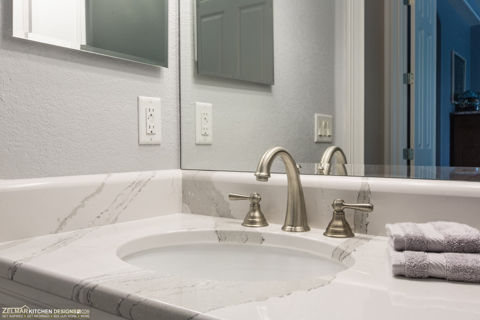 Inredning av ett klassiskt mellanstort badrum, med luckor med upphöjd panel, vita skåp, klinkergolv i porslin och grått golv