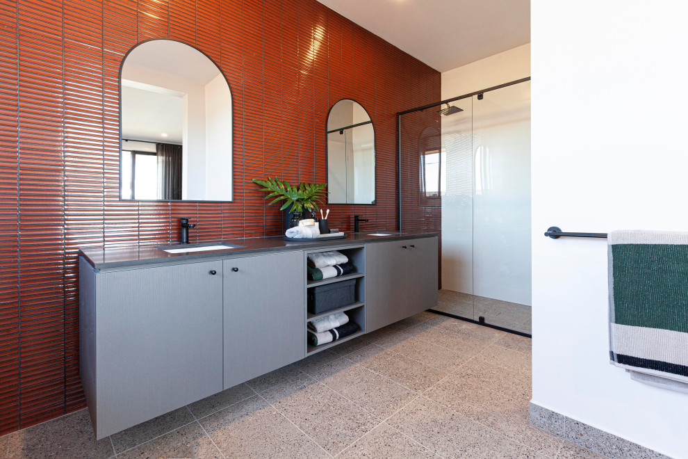 Пример оригинального дизайна: главная ванная комната в современном стиле с серыми фасадами, двойным душем, красной плиткой, керамической плиткой, белыми стенами, полом из керамической плитки, врезной раковиной, столешницей из искусственного кварца, серым полом, душем с распашными дверями, черной столешницей, подвесной тумбой, отдельно стоящей ванной и тумбой под две раковины