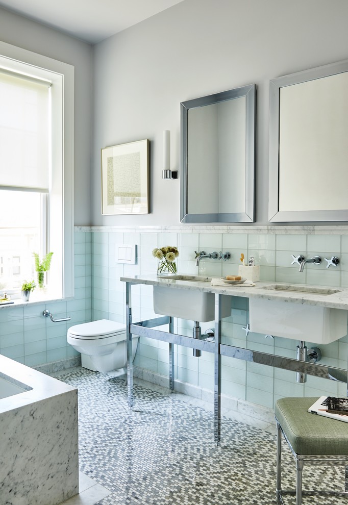 Свежая идея для дизайна: ванная комната в стиле неоклассика (современная классика) с полновстраиваемой ванной, синей плиткой, стеклянной плиткой, серыми стенами, полом из мозаичной плитки, врезной раковиной, серым полом и белой столешницей - отличное фото интерьера