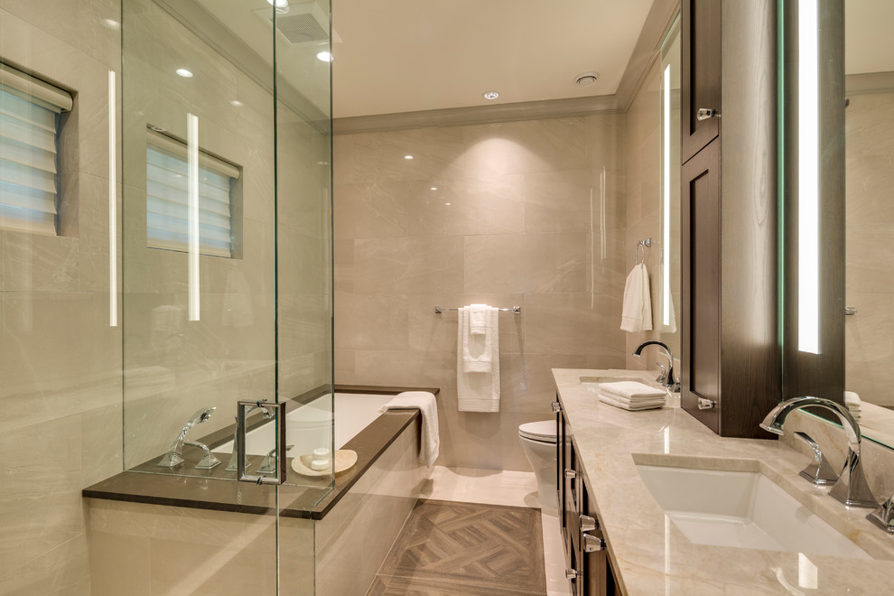 Idées déco pour une salle de bain classique en bois foncé avec un placard à porte shaker, une baignoire encastrée, une douche d'angle, un carrelage beige et un lavabo encastré.