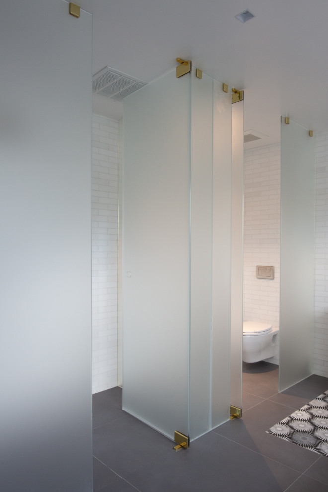 Idéer för stora eklektiska vitt badrum, med möbel-liknande, grå skåp, ett fristående badkar, en kantlös dusch, en vägghängd toalettstol, flerfärgad kakel, tunnelbanekakel, vita väggar, klinkergolv i porslin, ett undermonterad handfat, marmorbänkskiva, grått golv och dusch med gångjärnsdörr