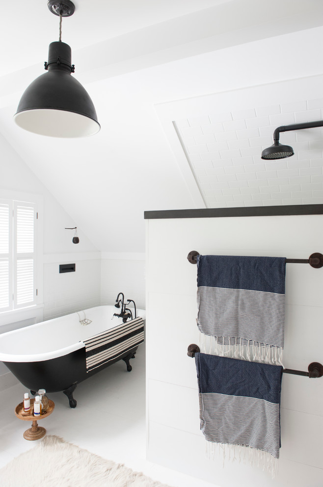 Cette image montre une petite salle de bain principale urbaine avec une baignoire sur pieds, un carrelage blanc, des carreaux de céramique, un mur blanc et parquet peint.