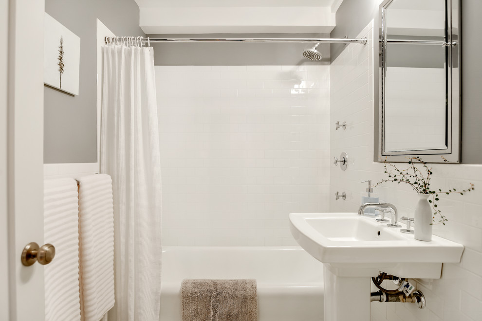 他の地域にあるトランジショナルスタイルのおしゃれなバスルーム (浴槽なし) (白いタイル、サブウェイタイル、グレーの壁、ペデスタルシンク、アルコーブ型浴槽、シャワー付き浴槽	、シャワーカーテン) の写真
