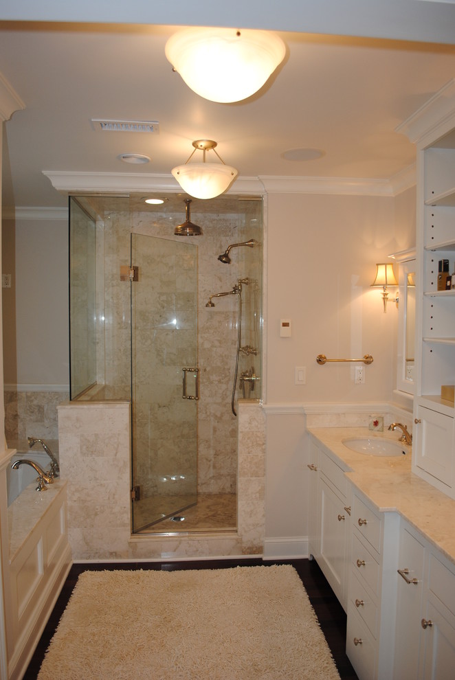 Corner shower - mid-sized traditional master beige tile and stone tile dark wood floor corner shower idea in New York with white cabinets, an undermount tub, beige walls, an undermount sink, marble countertops and recessed-panel cabinets