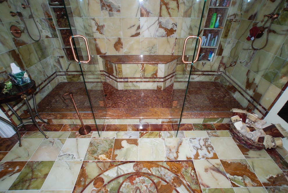 Foto di un'ampia stanza da bagno padronale mediterranea con lavabo sottopiano, ante con bugna sagomata, ante con finitura invecchiata, doccia alcova, WC a due pezzi, piastrelle verdi, piastrelle in pietra, pareti beige e pavimento in marmo