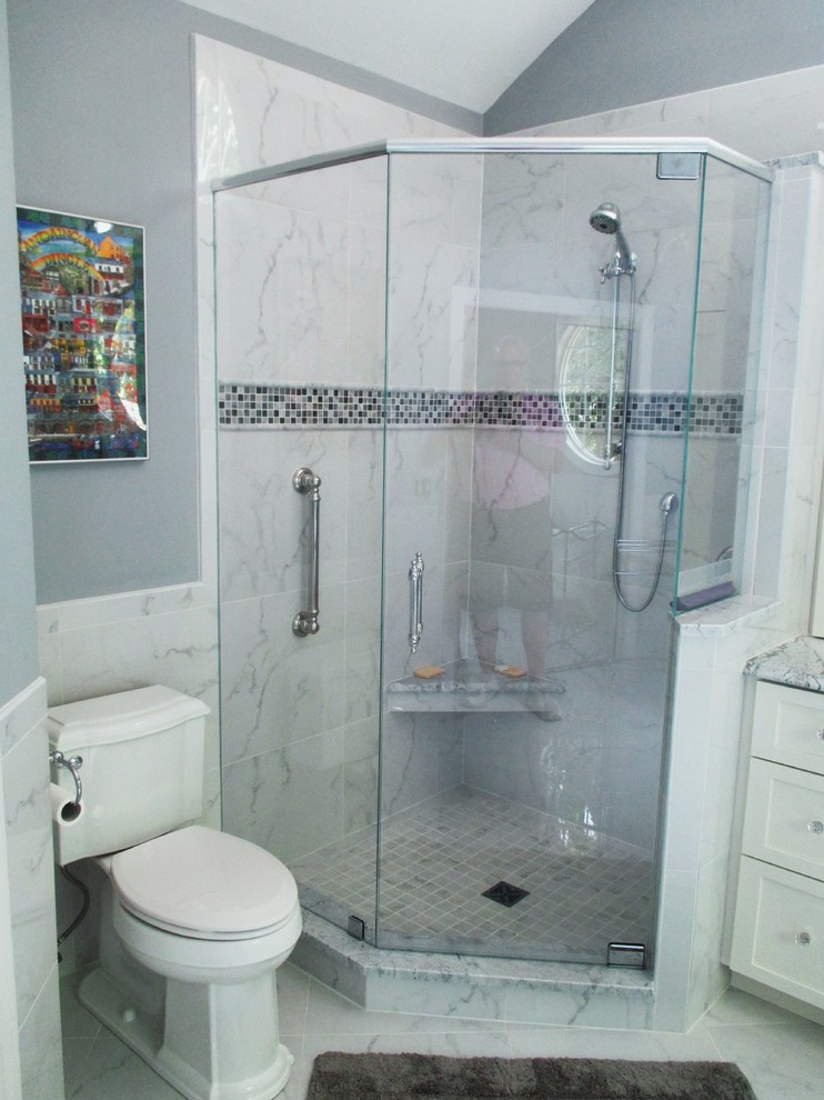 Aménagement d'une salle de bain principale classique avec des portes de placard blanches, un plan de toilette en marbre, une baignoire sur pieds, une douche d'angle, des carreaux de porcelaine, un mur gris et un sol en carrelage de porcelaine.