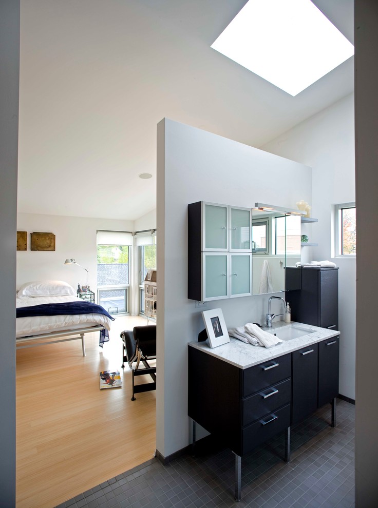На фото: ванная комната в современном стиле с врезной раковиной, плоскими фасадами, черными фасадами и серой плиткой