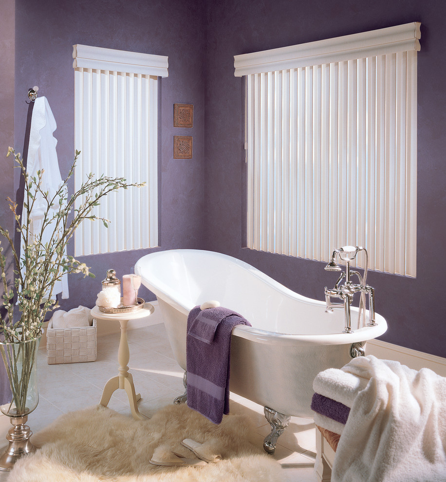 Пример оригинального дизайна: главная ванная комната среднего размера в современном стиле с ванной на ножках, фиолетовыми стенами и полом из известняка