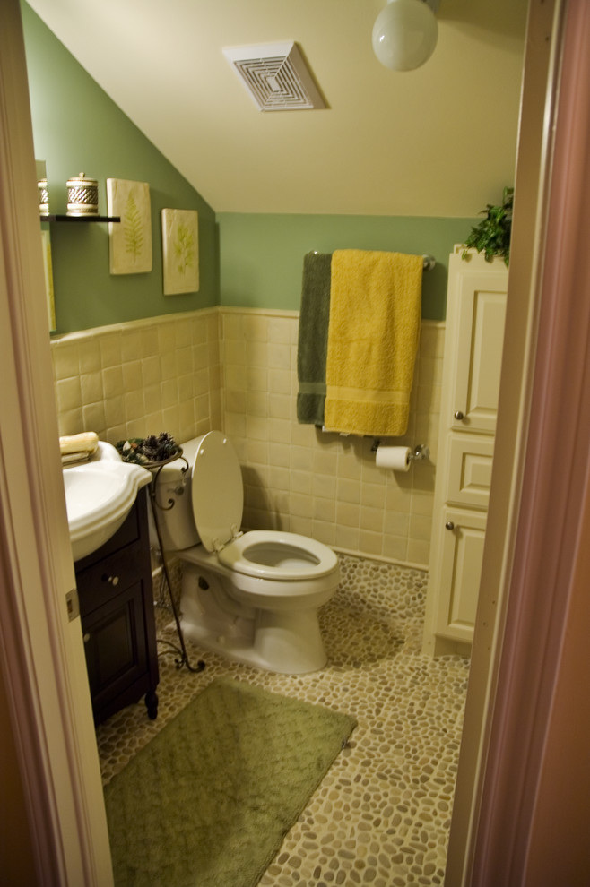 Photo of a small traditional bathroom in Houston with a vessel sink, recessed-panel cabinets, white cabinets, a one-piece toilet, yellow tiles, ceramic tiles, green walls and pebble tile flooring.