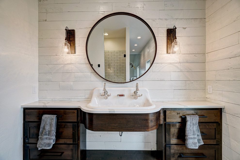 Foto på ett rustikt vit badrum, med skåp i mörkt trä, vita väggar, ett avlångt handfat och skåp i shakerstil