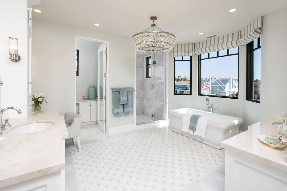 Klassisches Badezimmer mit weißen Schränken, freistehender Badewanne, weißer Wandfarbe, Unterbauwaschbecken, weißem Boden, beiger Waschtischplatte, WC-Raum und Doppelwaschbecken in Orange County
