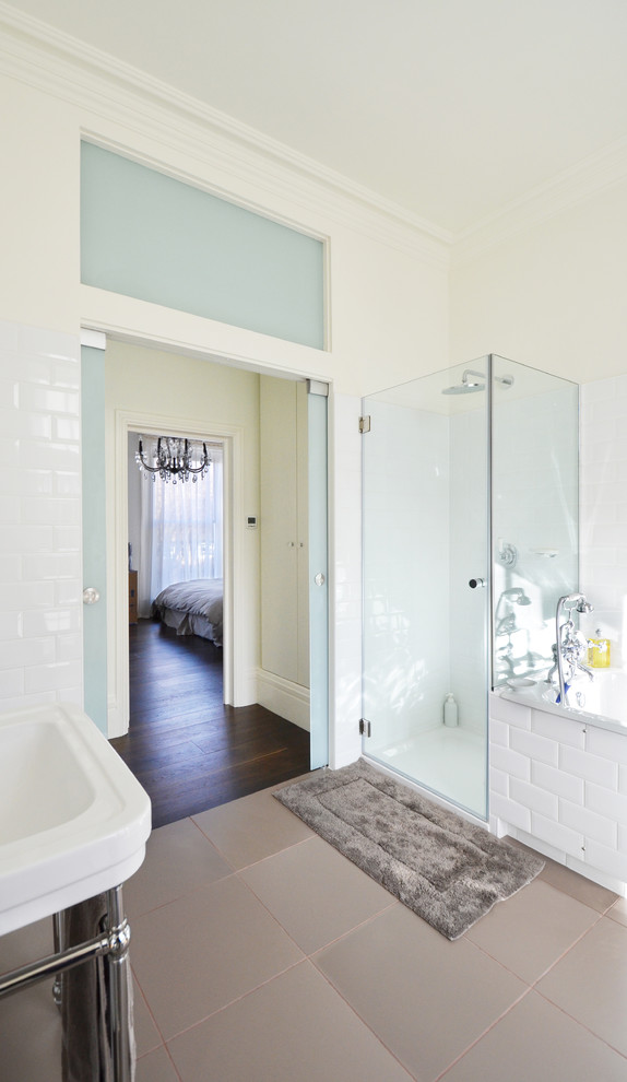 Modern inredning av ett stort en-suite badrum, med möbel-liknande, vit kakel, keramikplattor, ett undermonterat badkar, en dubbeldusch, en toalettstol med separat cisternkåpa, ett väggmonterat handfat, vita väggar och klinkergolv i keramik
