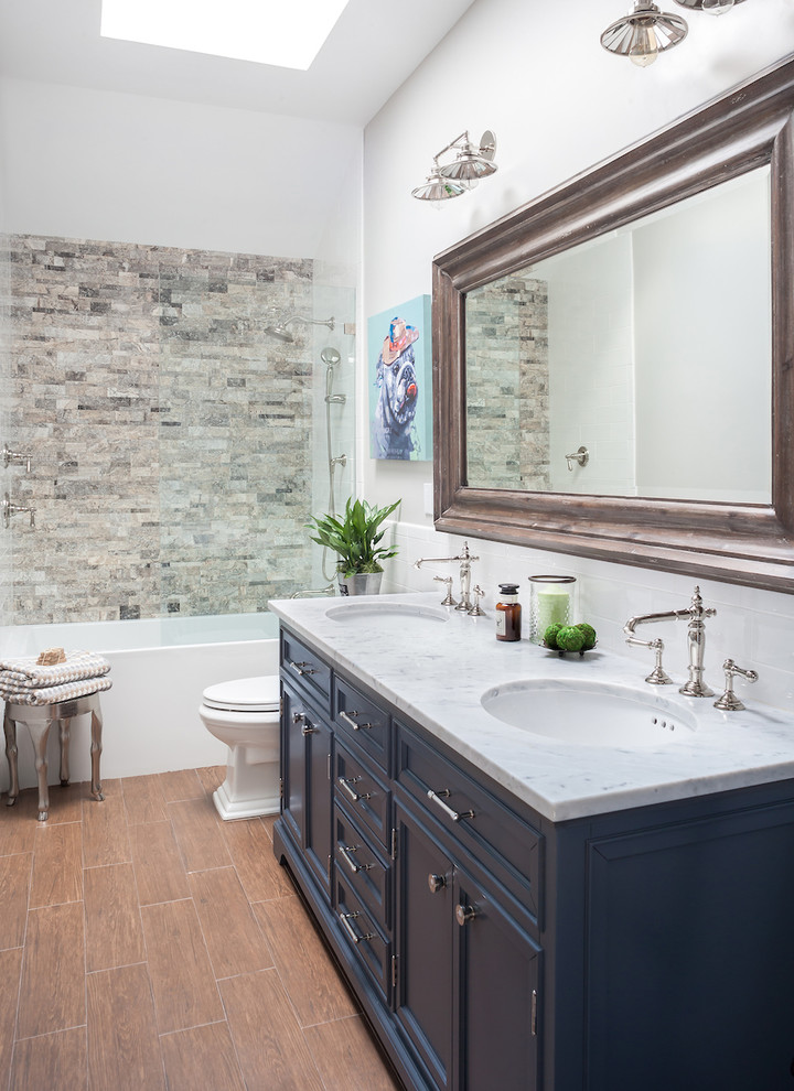 Пример оригинального дизайна: детская ванная комната среднего размера в стиле неоклассика (современная классика) с синими фасадами, ванной в нише, душем над ванной, унитазом-моноблоком, коричневой плиткой, плиткой кабанчик, серыми стенами, полом из керамогранита, врезной раковиной и мраморной столешницей