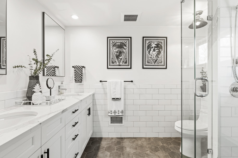 ニューヨークにあるトランジショナルスタイルのおしゃれな浴室 (落し込みパネル扉のキャビネット、白いキャビネット、アルコーブ型シャワー、白いタイル、サブウェイタイル、白い壁、アンダーカウンター洗面器、グレーの床、白い洗面カウンター) の写真