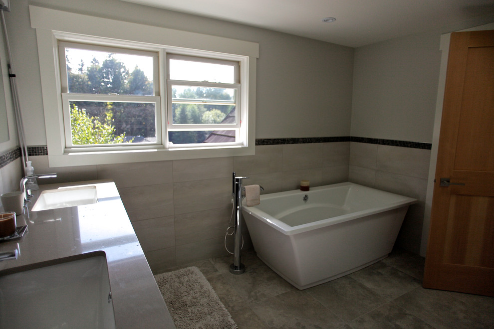 Example of a mid-sized minimalist master white tile and ceramic tile marble floor freestanding bathtub design in Vancouver with an undermount sink, recessed-panel cabinets, dark wood cabinets, granite countertops, a one-piece toilet and white walls
