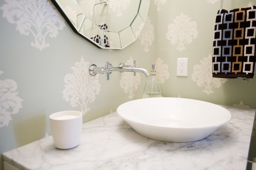 Exemple d'une salle d'eau chic avec un placard en trompe-l'oeil, des portes de placard blanches, WC à poser, un carrelage noir et blanc, des carreaux de porcelaine, un mur vert, une vasque et un plan de toilette en marbre.