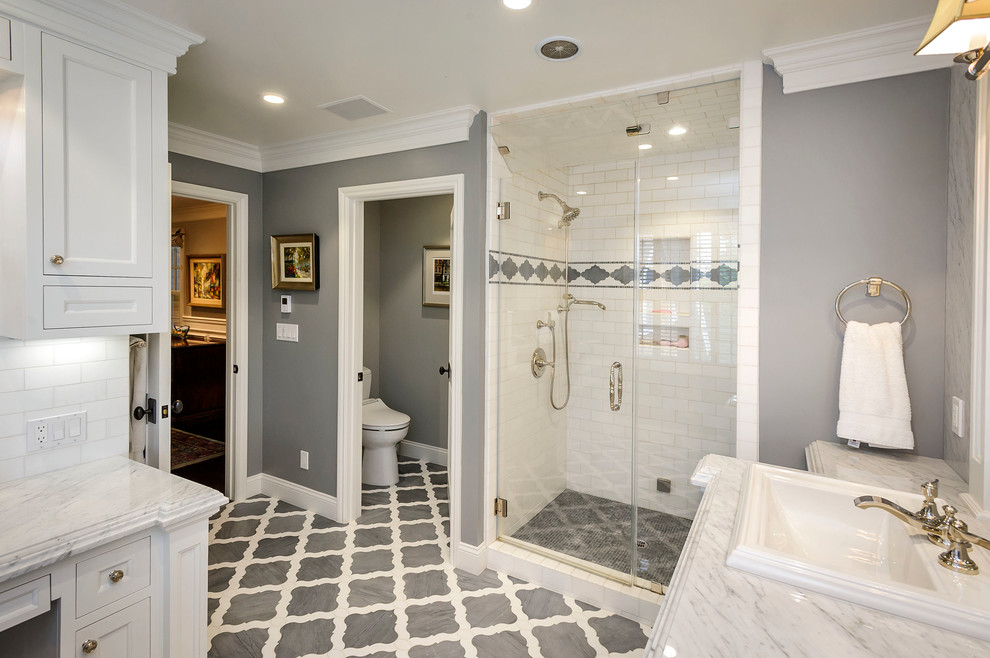 Idéer för att renovera ett vintage grå grått badrum, med ett nedsänkt handfat, luckor med infälld panel, vita skåp, en dusch i en alkov, en toalettstol med separat cisternkåpa, vit kakel, tunnelbanekakel och flerfärgat golv