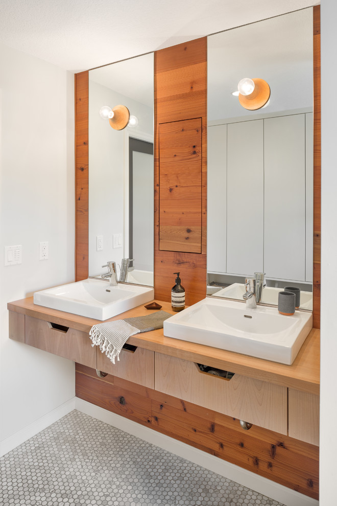 Imagen de cuarto de baño principal escandinavo pequeño con lavabo encastrado, armarios con paneles lisos, puertas de armario de madera clara, encimera de madera, paredes blancas, suelo con mosaicos de baldosas y encimeras marrones