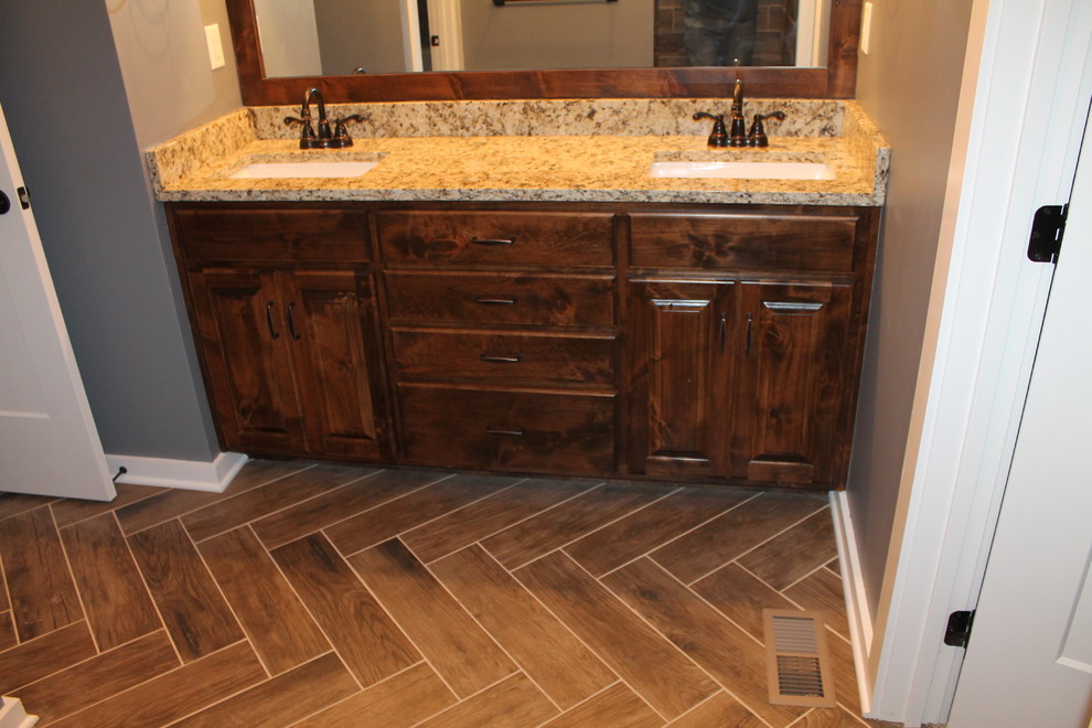 Rustik inredning av ett mellanstort brun brunt en-suite badrum, med luckor med upphöjd panel, bruna skåp, porslinskakel, blå väggar, klinkergolv i porslin, ett undermonterad handfat, granitbänkskiva och brunt golv