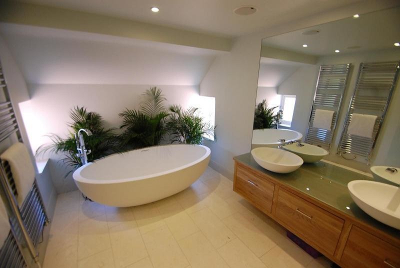 Inspiration för en-suite badrum, med ett fristående handfat, möbel-liknande, skåp i ljust trä, bänkskiva i glas, ett fristående badkar, beige kakel, stenkakel, vita väggar och travertin golv