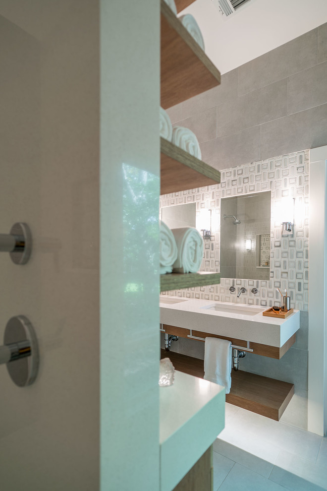 Cette photo montre une salle de bain principale chic de taille moyenne avec un carrelage gris, un lavabo encastré, un plan de toilette en quartz et aucune cabine.