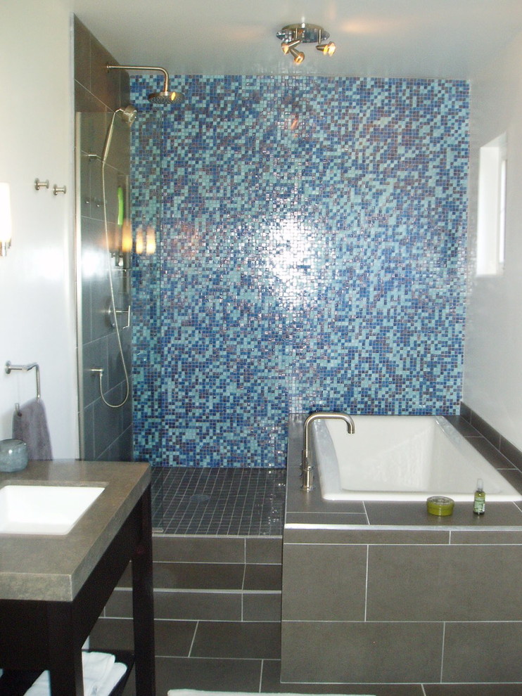 Idéer för att renovera ett stort funkis en-suite badrum, med ett undermonterad handfat, bänkskiva i betong, keramikplattor, öppna hyllor, svarta skåp, en toalettstol med separat cisternkåpa, blå kakel, vita väggar, klinkergolv i porslin, grått golv, med dusch som är öppen, ett undermonterat badkar och våtrum