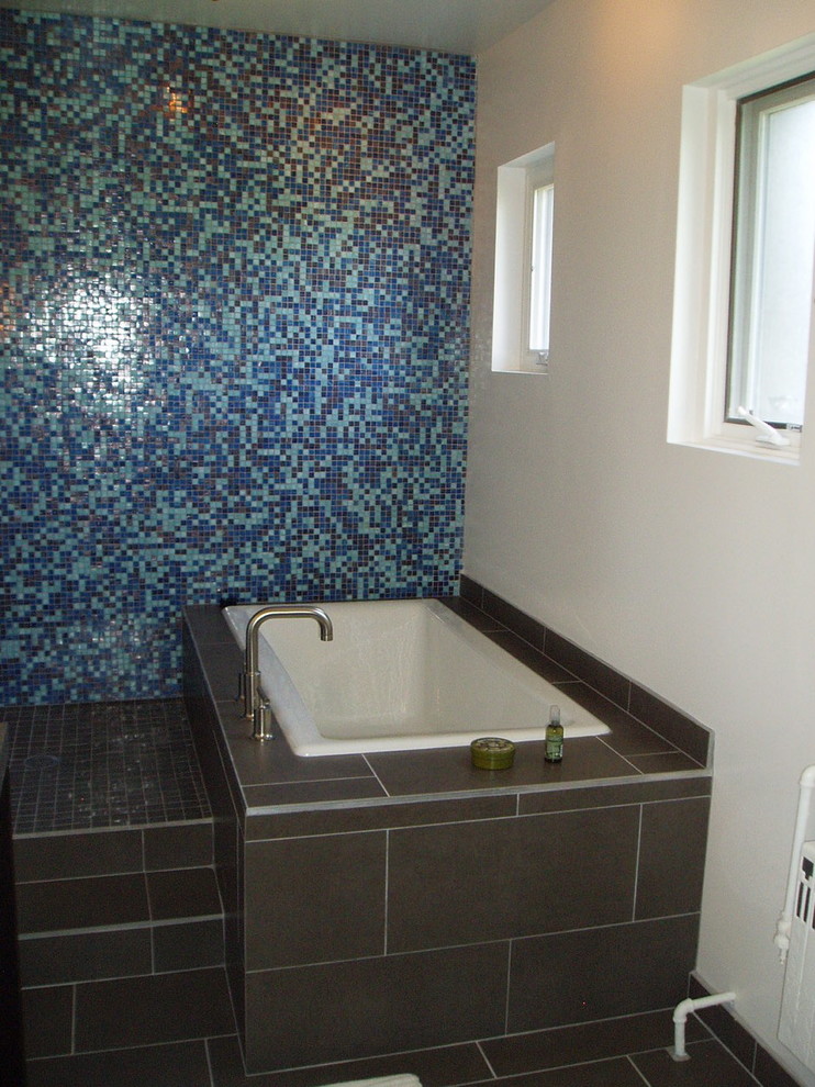 This is an example of a large contemporary ensuite wet room bathroom in Chicago with a submerged sink, ceramic tiles, open cabinets, black cabinets, a submerged bath, a two-piece toilet, blue tiles, white walls, porcelain flooring, concrete worktops, grey floors and an open shower.