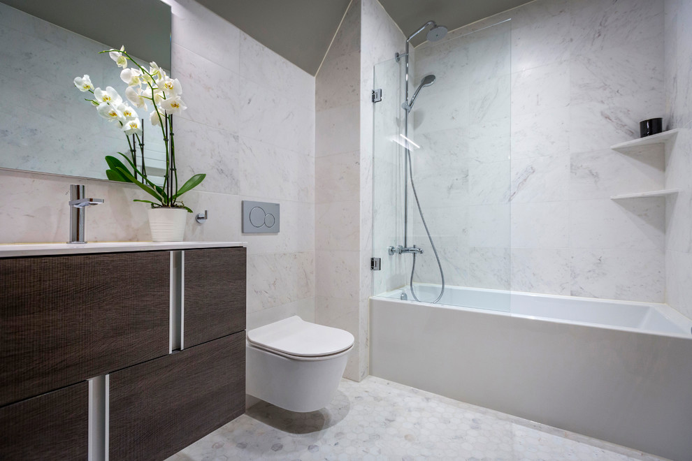 Exempel på ett modernt vit vitt badrum, med släta luckor, skåp i mörkt trä, ett badkar i en alkov, en dusch/badkar-kombination, en vägghängd toalettstol, grå kakel, ett undermonterad handfat, grått golv och dusch med gångjärnsdörr
