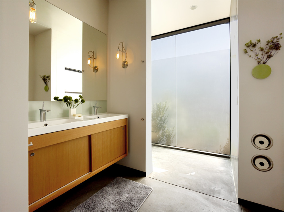 Идея дизайна: ванная комната в стиле модернизм с монолитной раковиной, плоскими фасадами, фасадами цвета дерева среднего тона, душем в нише, белыми стенами, бетонным полом и окном
