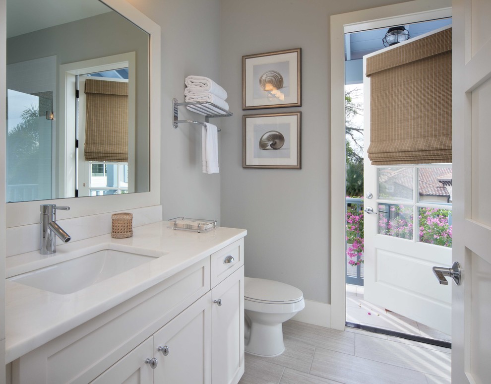 На фото: ванная комната в морском стиле с врезной раковиной, фасадами в стиле шейкер, белыми фасадами, серой плиткой, керамогранитной плиткой, серыми стенами и полом из керамогранита