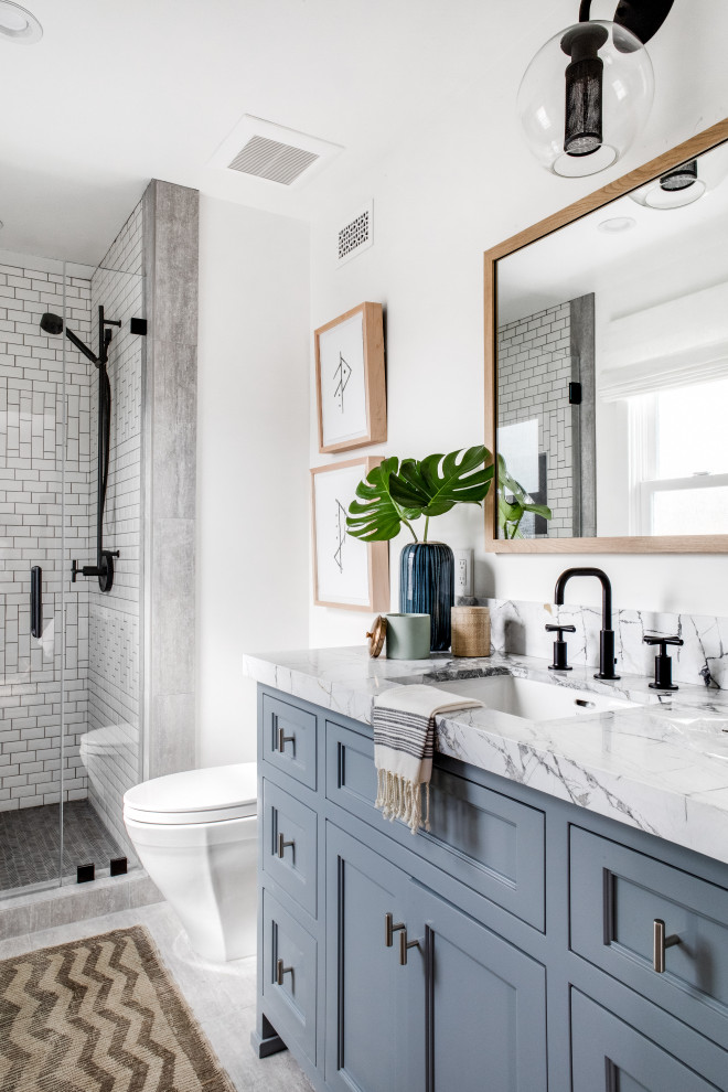Klassisches Duschbad mit Schrankfronten mit vertiefter Füllung, grauen Schränken, Duschnische, weißen Fliesen, weißer Wandfarbe, buntem Boden, Falttür-Duschabtrennung, Einzelwaschbecken und eingebautem Waschtisch in Orange County