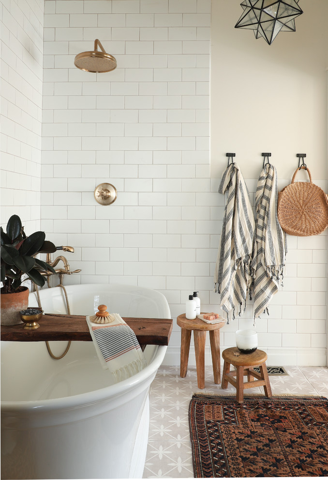 ミネアポリスにあるカントリー風のおしゃれな浴室 (置き型浴槽、シャワー付き浴槽	、白いタイル、サブウェイタイル、ベージュの壁、グレーの床) の写真