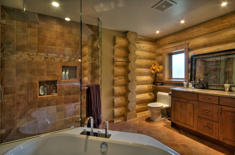 Inspiration pour une salle de bain principale traditionnelle en bois brun avec un placard avec porte à panneau surélevé, une baignoire d'angle, une douche d'angle, WC à poser, un carrelage marron, un mur beige, un sol en carrelage de céramique, un lavabo posé, un plan de toilette en granite et un sol beige.