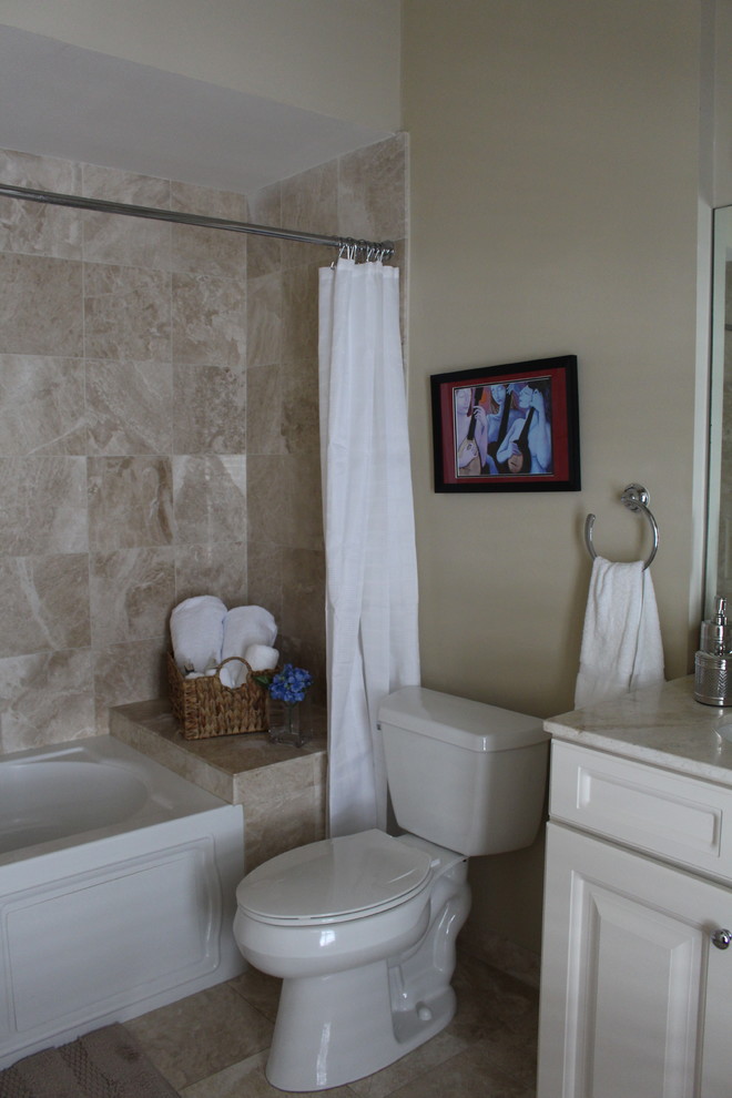 ニューオリンズにある低価格の小さなトランジショナルスタイルのおしゃれな子供用バスルーム (レイズドパネル扉のキャビネット、白いキャビネット、アルコーブ型浴槽、シャワー付き浴槽	、分離型トイレ、ベージュのタイル、セラミックタイル、ベージュの壁、セラミックタイルの床、クオーツストーンの洗面台、シャワーカーテン) の写真