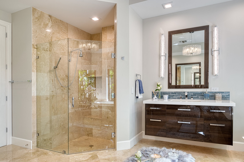 マイアミにある地中海スタイルのおしゃれな浴室 (フラットパネル扉のキャビネット、茶色いキャビネット、コーナー設置型シャワー、ベージュのタイル、グレーの壁、アンダーカウンター洗面器、ベージュの床、開き戸のシャワー、白い洗面カウンター) の写真