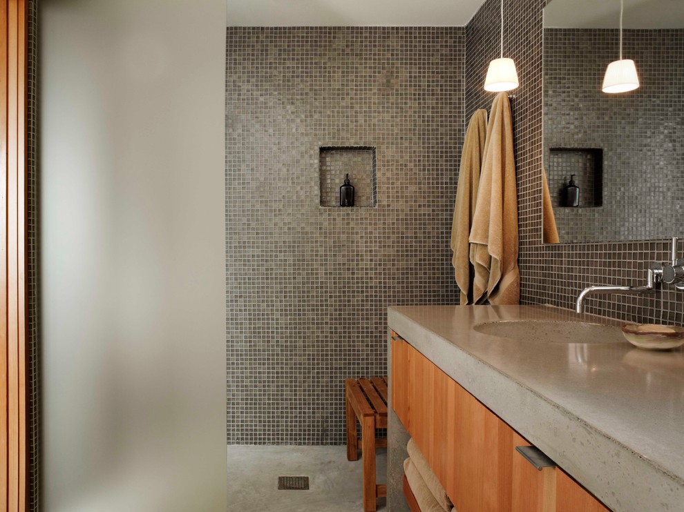 Свежая идея для дизайна: ванная комната в стиле модернизм с монолитной раковиной, плоскими фасадами, фасадами цвета дерева среднего тона, открытым душем, коричневой плиткой, плиткой мозаикой, столешницей из бетона, бетонным полом и открытым душем - отличное фото интерьера