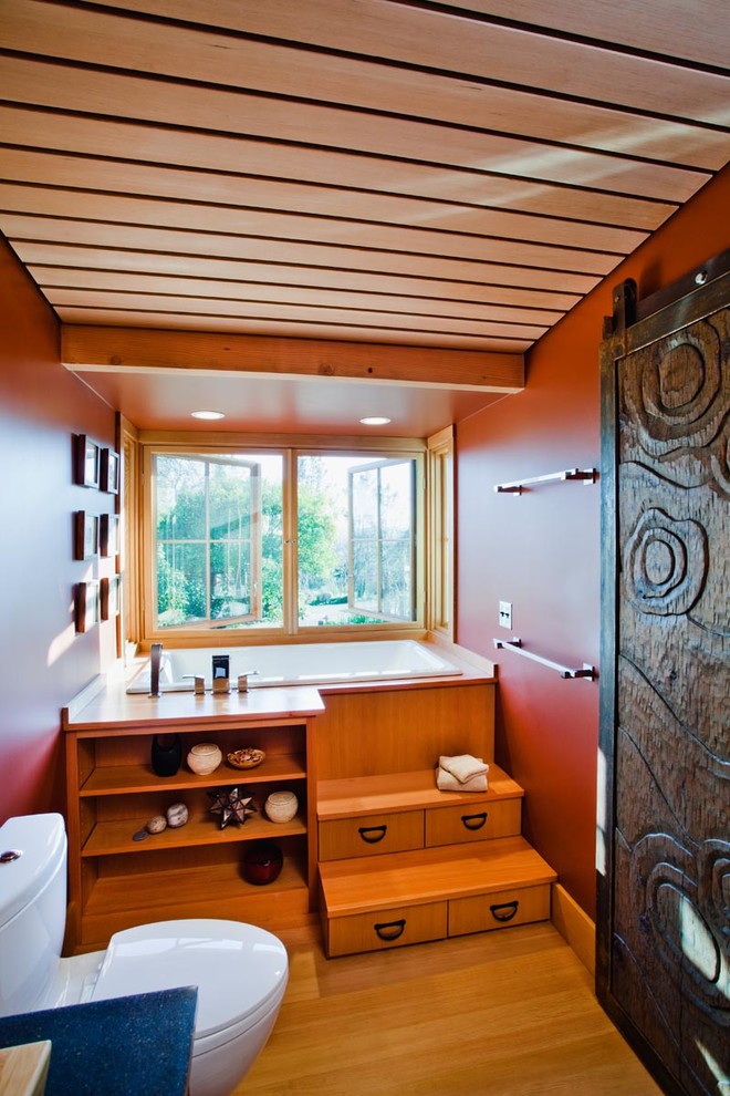 Diseño de cuarto de baño tradicional renovado con lavabo sobreencimera, puertas de armario de madera oscura, paredes rojas y aseo y ducha