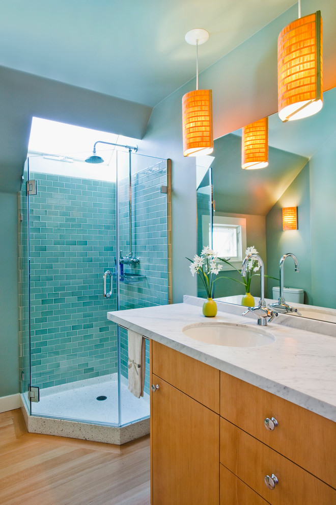 Idéer för ett modernt badrum, med en hörndusch, blå väggar, ljust trägolv och marmorbänkskiva