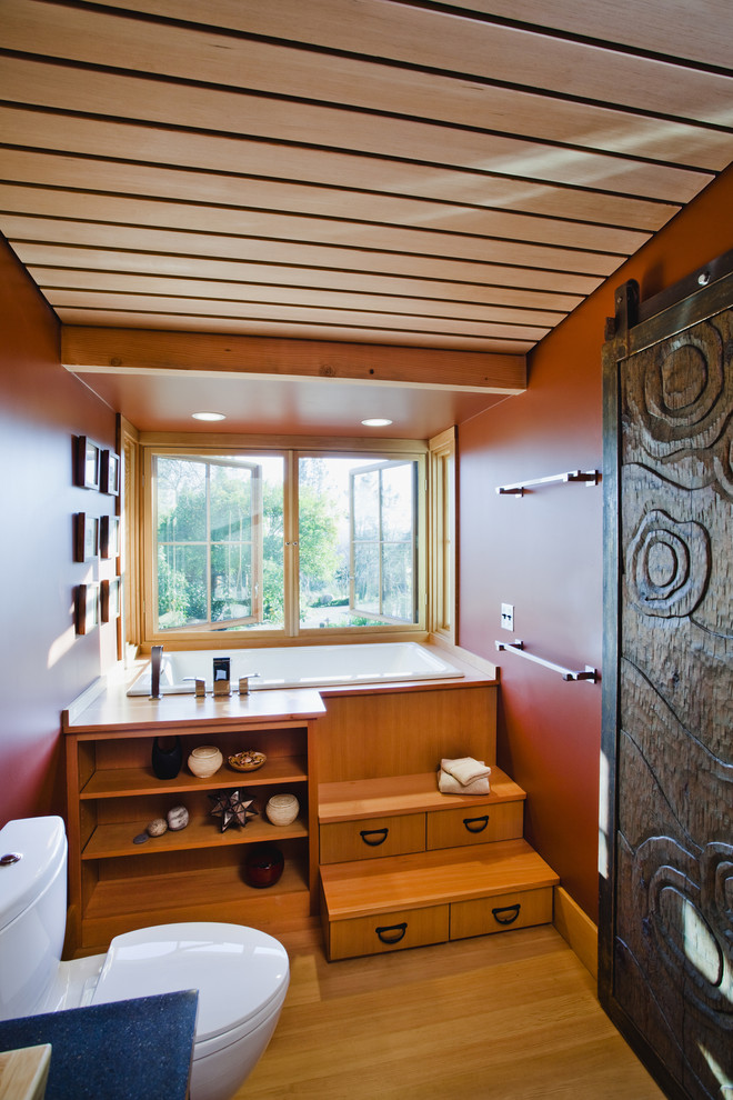 Inspiration for a farmhouse shower room bathroom in San Francisco with medium wood cabinets, a japanese bath, a two-piece toilet, red walls and medium hardwood flooring.