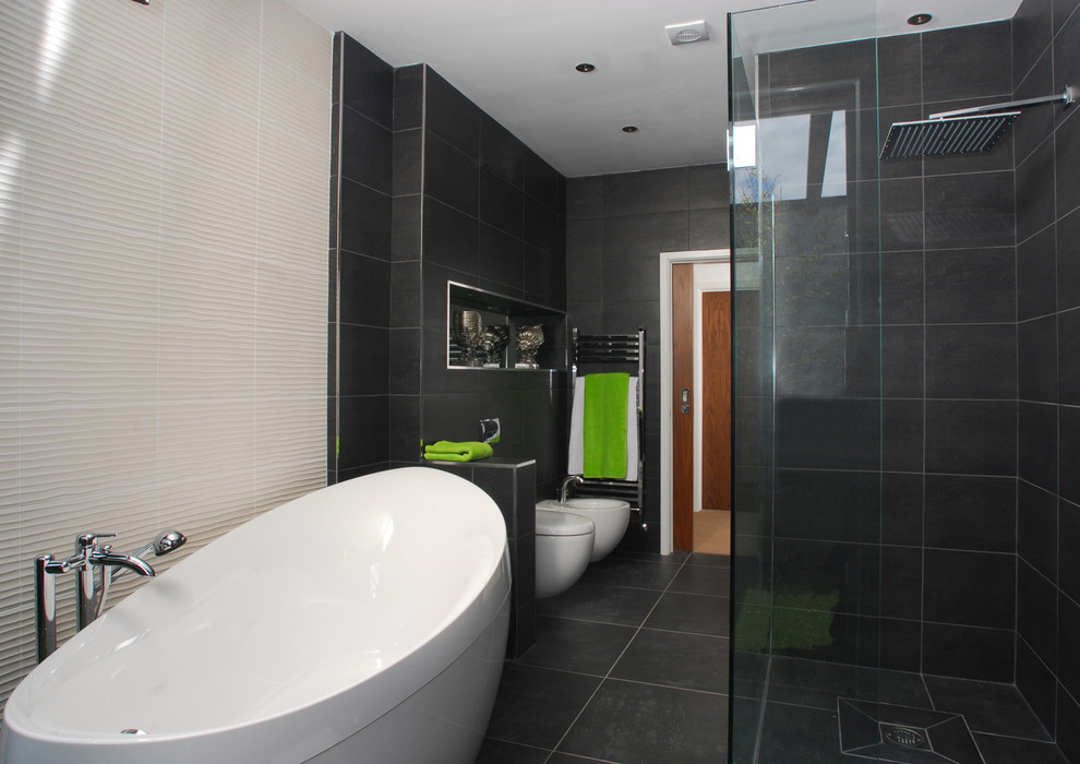 Пример оригинального дизайна: большая главная ванная комната в современном стиле с подвесной раковиной, отдельно стоящей ванной, открытым душем, инсталляцией, черной плиткой, керамогранитной плиткой, черными стенами и полом из керамогранита