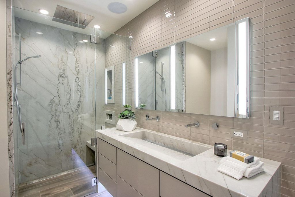 Bild på ett stort funkis grå grått badrum med dusch, med släta luckor, beige skåp, ett badkar i en alkov, en kantlös dusch, en toalettstol med hel cisternkåpa, grå kakel, stenhäll, klinkergolv i porslin, ett integrerad handfat, marmorbänkskiva, brunt golv och dusch med gångjärnsdörr