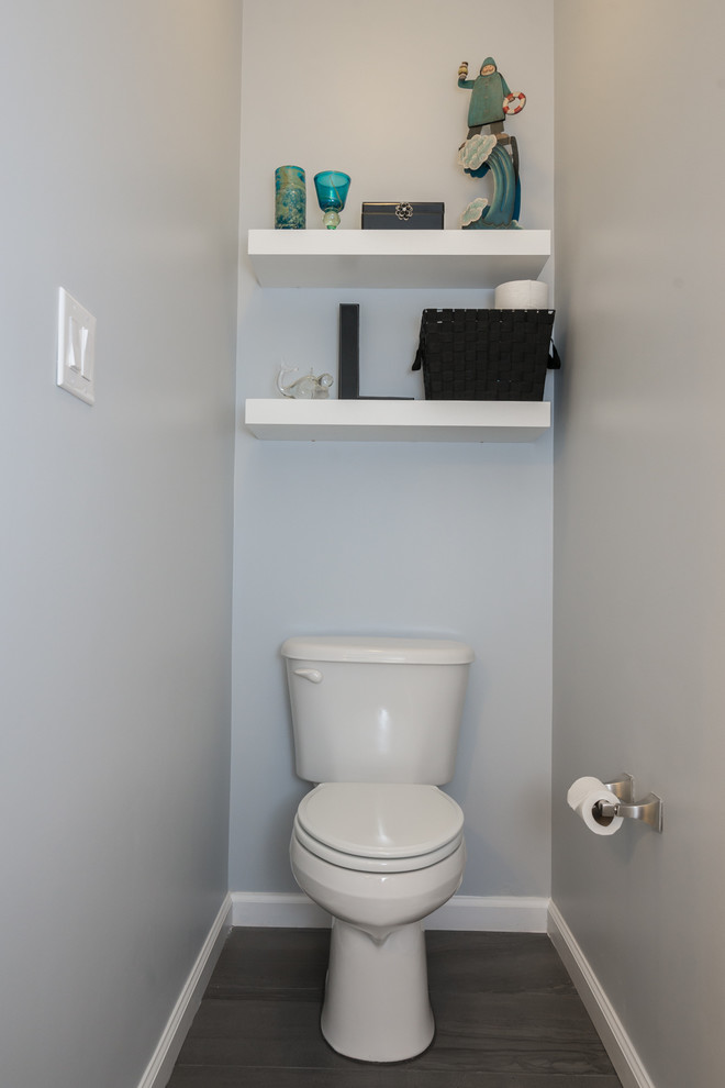 Cette photo montre un WC et toilettes chic de taille moyenne avec un placard à porte shaker, des portes de placard blanches, WC séparés, un mur gris, un sol en carrelage de porcelaine, un lavabo encastré et un plan de toilette en marbre.